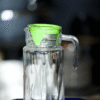 Stylish and practical, this clear glass pitcher features a bold green lid with a built-in spout for easy pouring. Designed for serving cold beverages like juice, water, or iced tea, it's perfect for home, events, or office use. The transparent body lets you see the contents at a glance, while the lid helps keep things fresh and spill-free. A must-have for everyday hydration or entertaining guests.
